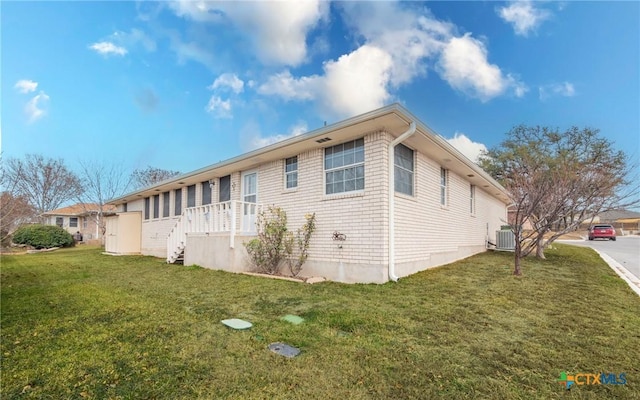 view of property exterior with a yard and central AC