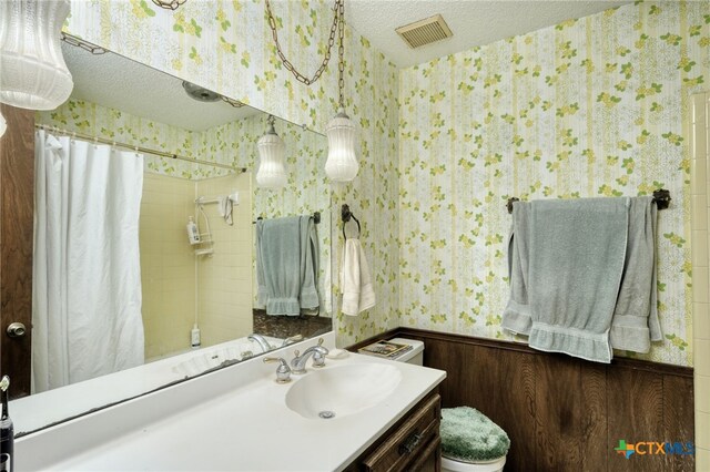 1104 Saint Williams Ave, Round Rock, TX 78681 - bathroom featuring wallpapered walls, a textured ceiling, vanity, and toilet