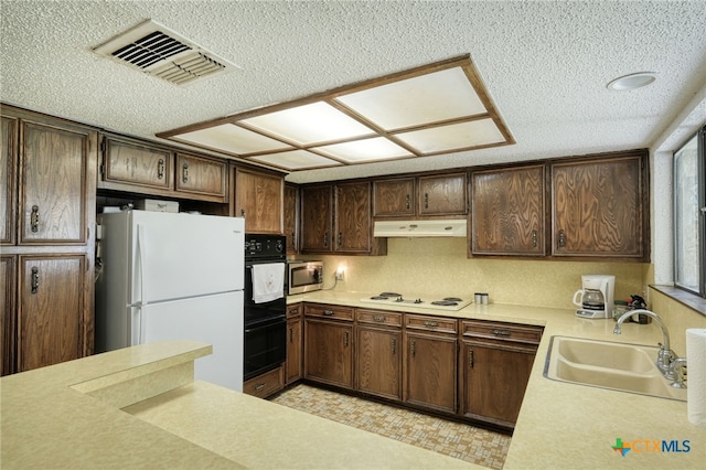 1104 Saint Williams Ave, Round Rock, TX 78681 - kitchen featuring white appliances, a sink, under cabinet range hood, a textured ceiling, and light countertops