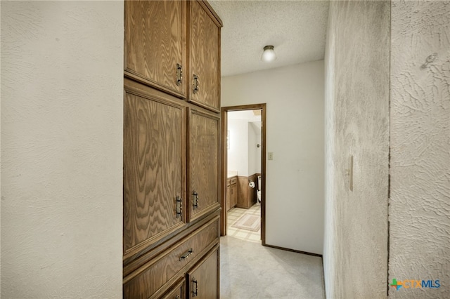 1104 Saint Williams Ave, Round Rock, TX 78681 - hallway with light colored carpet, a textured ceiling, a textured wall, and baseboards
