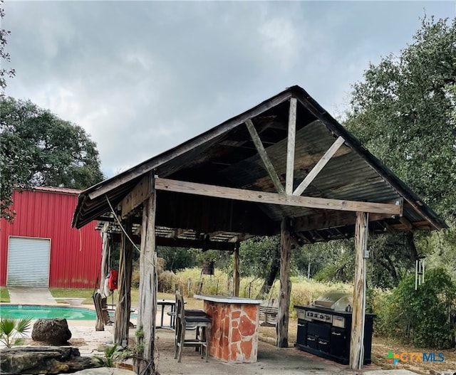 view of patio with an outbuilding and area for grilling