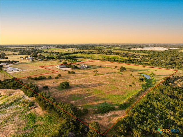 aerial view at dusk featuring a rural view