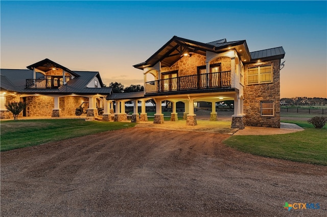 view of front of home featuring a lawn and a balcony