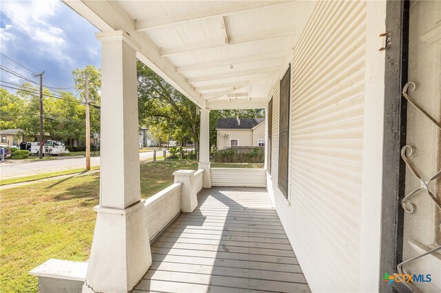 wooden deck featuring a yard and covered porch