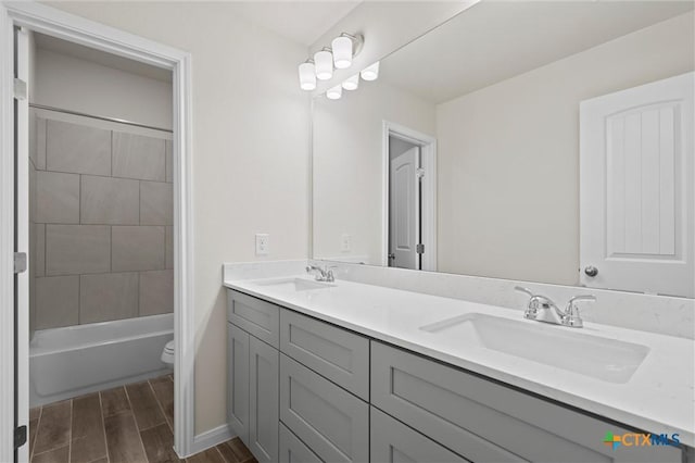 full bathroom with vanity, tiled shower / bath combo, and toilet