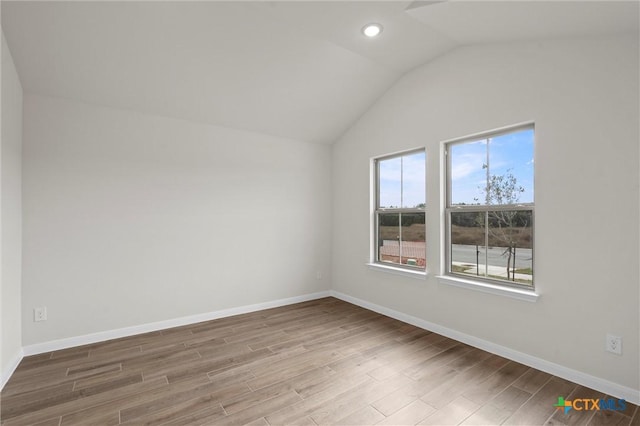 empty room with lofted ceiling and hardwood / wood-style floors