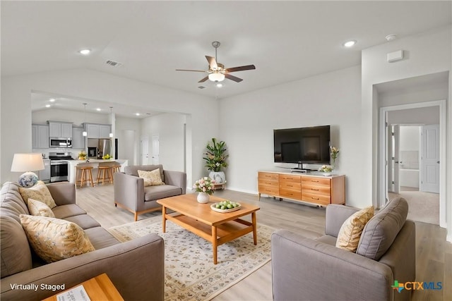 living room with vaulted ceiling, ceiling fan, and light hardwood / wood-style floors