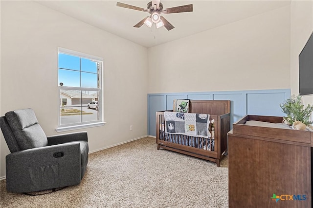 carpeted bedroom featuring wainscoting
