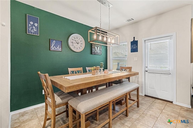 dining space with baseboards, a chandelier, visible vents, and light tile patterned floors