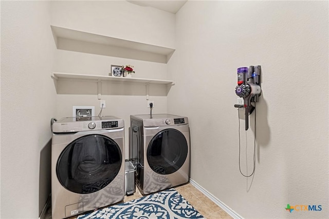 washroom with baseboards, independent washer and dryer, laundry area, and light tile patterned floors