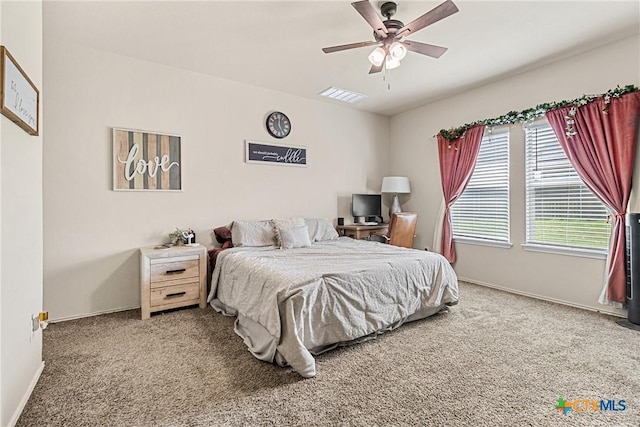 carpeted bedroom with visible vents, a ceiling fan, and baseboards