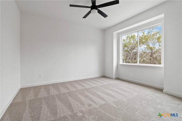 carpeted spare room with ceiling fan