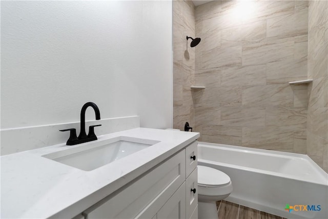 full bathroom featuring vanity, tiled shower / bath, wood-type flooring, and toilet