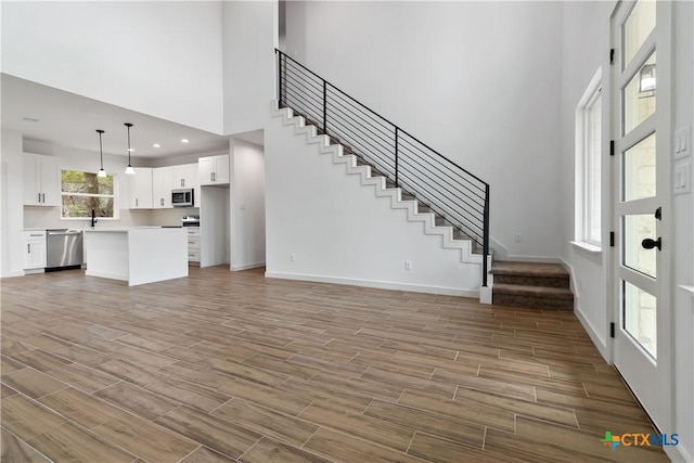 unfurnished living room featuring a towering ceiling