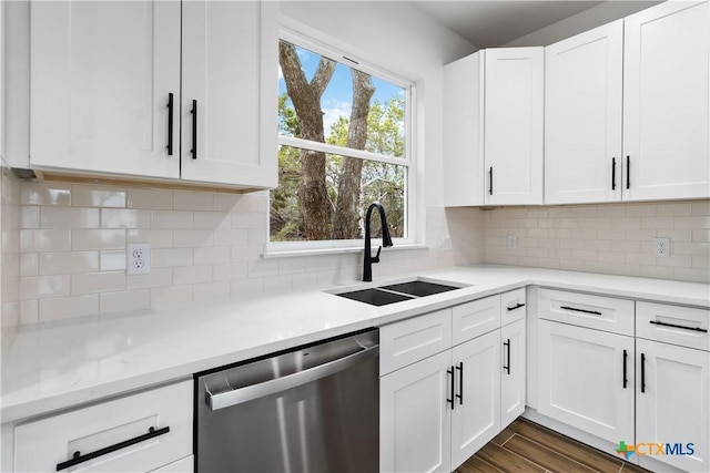 kitchen featuring dishwasher, sink, white cabinets, dark hardwood / wood-style flooring, and decorative backsplash