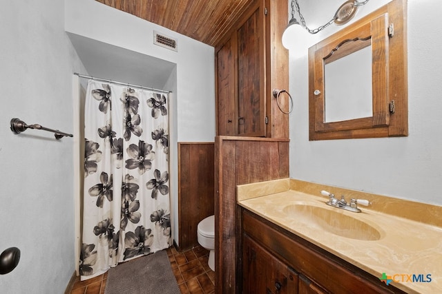 bathroom with a shower with curtain, vanity, wood ceiling, wooden walls, and toilet