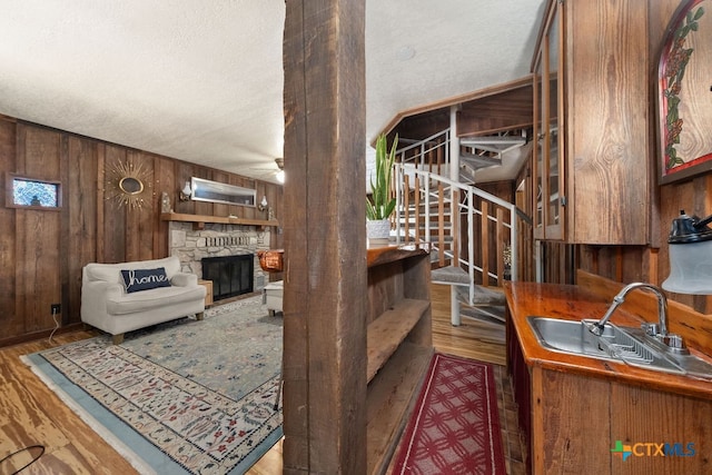 living room featuring a fireplace, hardwood / wood-style flooring, and wooden walls