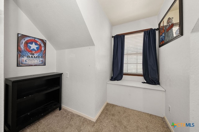 interior space featuring light carpet and vaulted ceiling