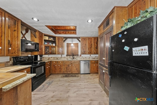 kitchen featuring light hardwood / wood-style floors, decorative backsplash, black appliances, a textured ceiling, and sink