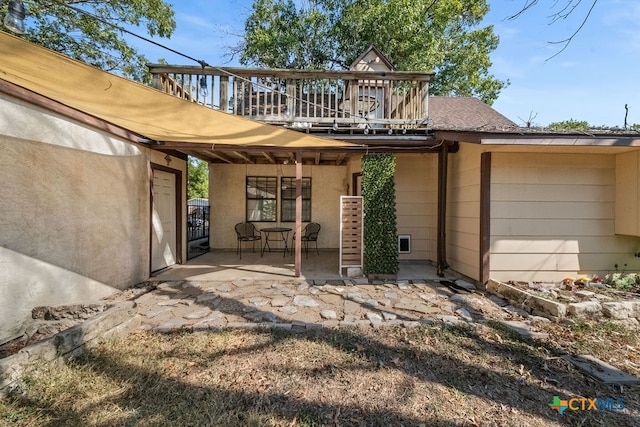 back of property featuring a balcony and a patio area