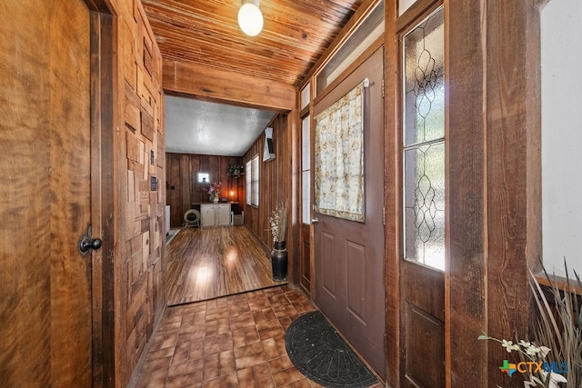 foyer with dark hardwood / wood-style flooring and wood walls