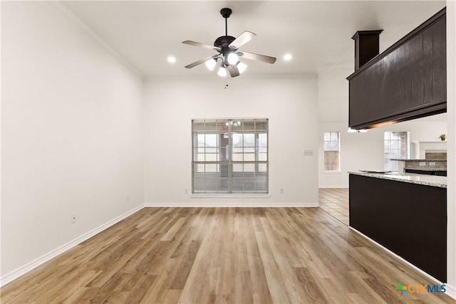 unfurnished living room featuring ceiling fan, light wood-type flooring, and ornamental molding