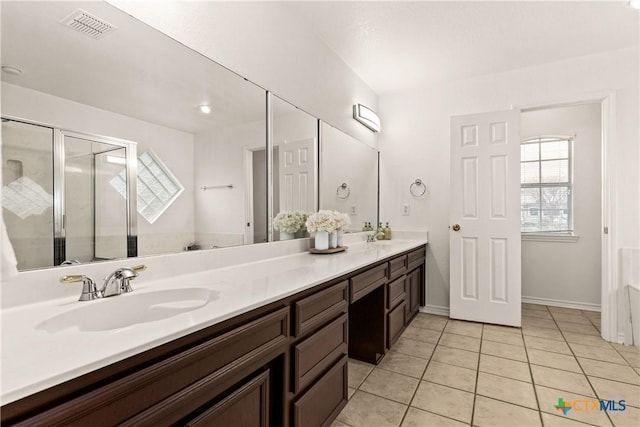 bathroom featuring tile patterned flooring, vanity, and walk in shower