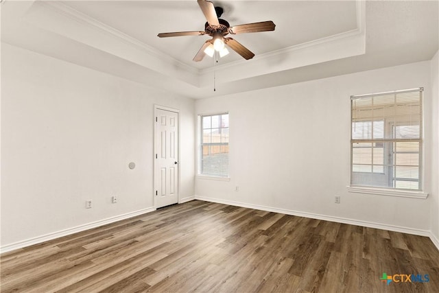 unfurnished room featuring hardwood / wood-style flooring, ceiling fan, crown molding, and a tray ceiling