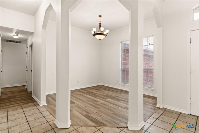 tiled entryway with a notable chandelier and ornamental molding