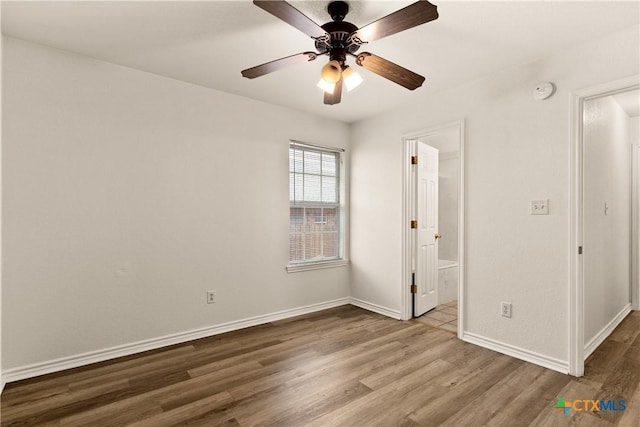 interior space with ceiling fan, ensuite bathroom, and hardwood / wood-style flooring