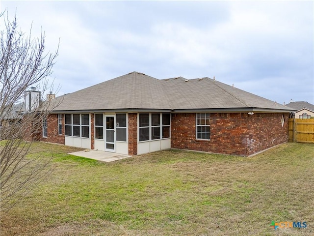 back of property with a lawn and a sunroom