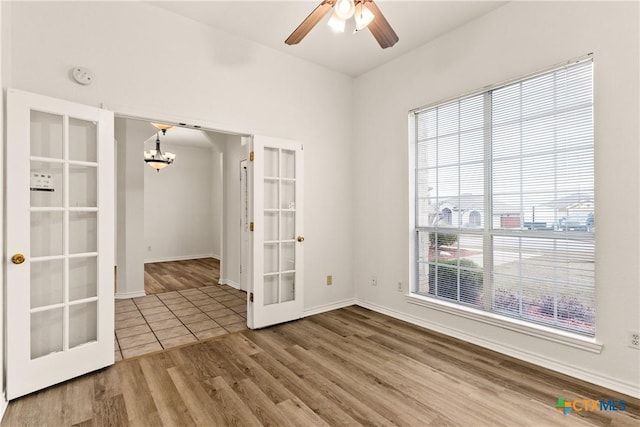 unfurnished room with hardwood / wood-style floors, ceiling fan, and french doors