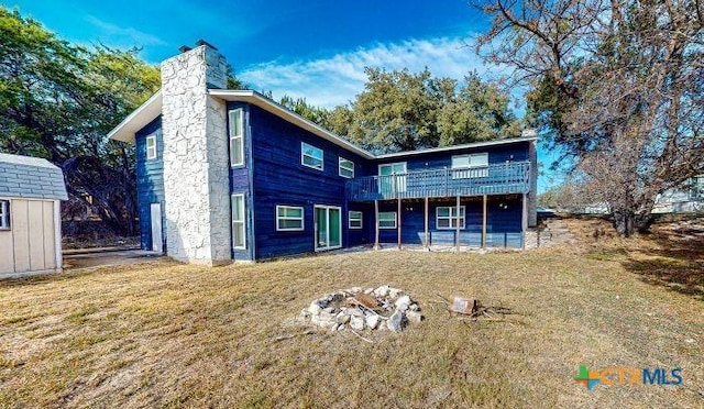 view of front of property featuring a storage unit, a deck, and a front lawn