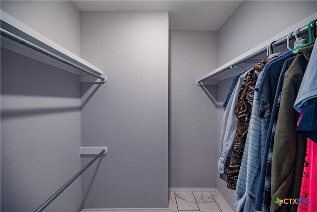 spacious closet featuring marble finish floor