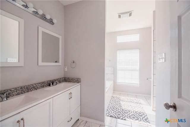 bathroom featuring visible vents, a sink, a bath, and double vanity