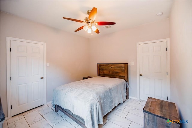 bedroom with marble finish floor, visible vents, and a ceiling fan