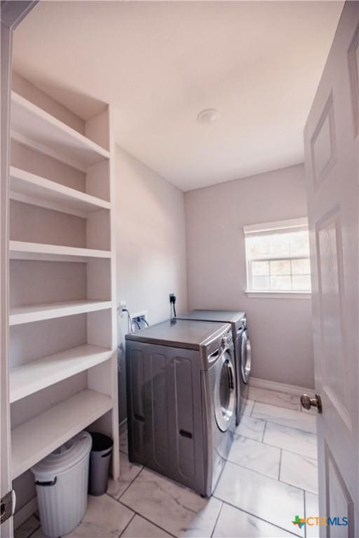 laundry area featuring laundry area, washing machine and dryer, marble finish floor, and baseboards