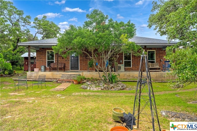 rear view of property featuring ac unit, covered porch, and a yard