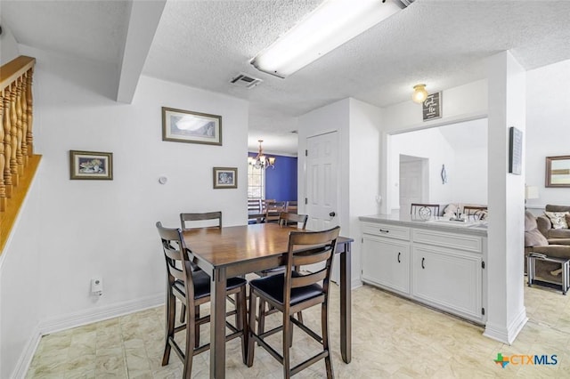 205 Magdalena Dr, Victoria, TX 77904 - dining room with an inviting chandelier, baseboards, a textured ceiling, and visible vents