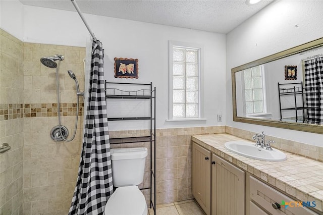 205 Magdalena Dr, Victoria, TX 77904 - bathroom with toilet, a textured ceiling, tiled shower, and vanity