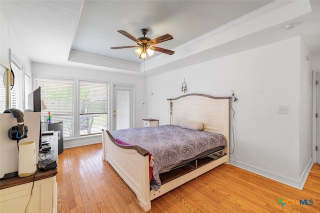 205 Magdalena Dr, Victoria, TX 77904 - bedroom featuring crown molding, a raised ceiling, light wood-style floors, a ceiling fan, and baseboards