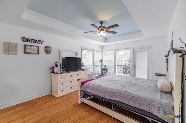 205 Magdalena Dr, Victoria, TX 77904 - bedroom with a ceiling fan, baseboards, a raised ceiling, and light wood-style floors