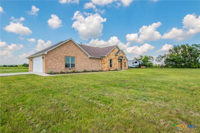 view of front of house featuring a garage, driveway, a front lawn, and brick siding