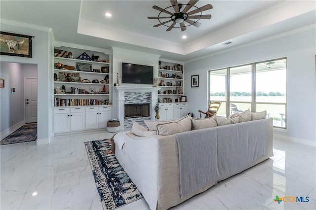 living room featuring built in features, a raised ceiling, marble finish floor, and baseboards