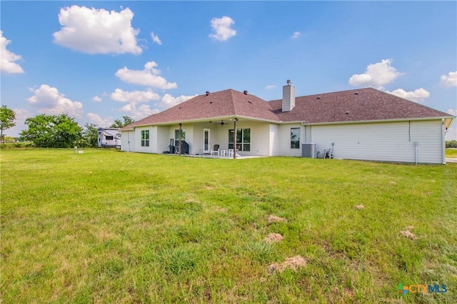 rear view of house with a lawn, a patio, ceiling fan, a chimney, and central air condition unit