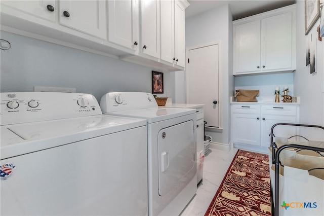 clothes washing area featuring cabinet space and washer and dryer