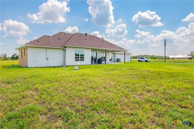 rear view of property featuring a yard and a patio area