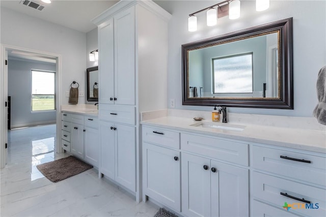 bathroom with marble finish floor, visible vents, and vanity