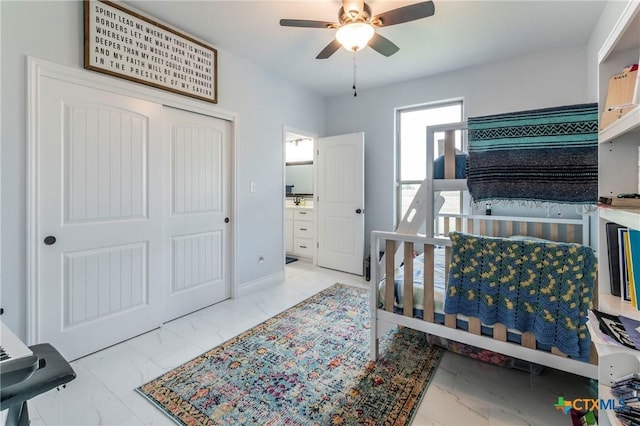 bedroom with ceiling fan, marble finish floor, a closet, and baseboards