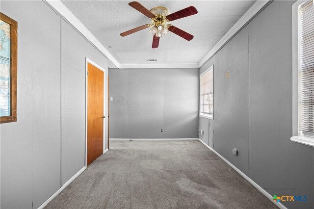 empty room with a textured ceiling, light colored carpet, and ceiling fan